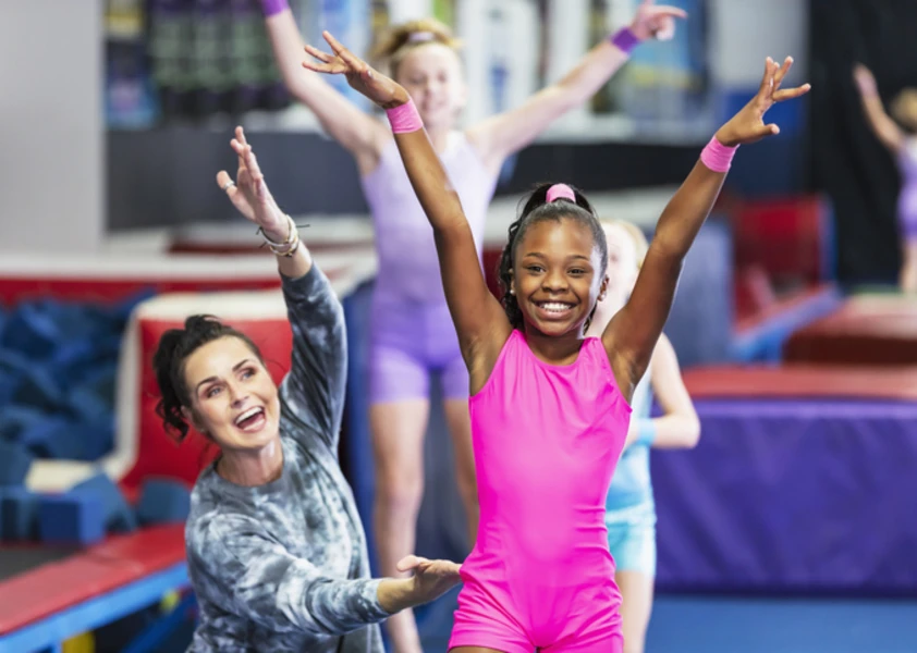 Élèves de gymnastiques et leur enseignante souriant 